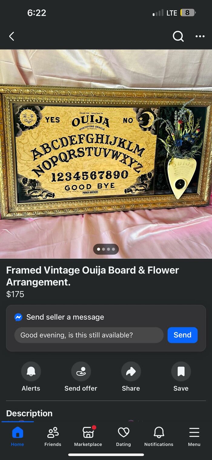 Framed vintage Ouija board with flower arrangement displayed on pink fabric, featured in craft shaming DIY projects.