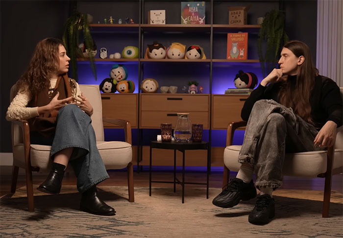 Two people seated and discussing predators targeting children's social media with specific comments in a cozy room setting.