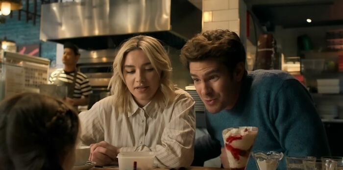 Andrew Garfield with a woman in a diner setting, highlighting his latest look and botox buzz in a casual scene.