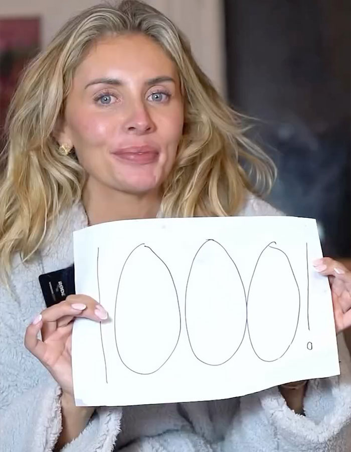 Woman with long blonde hair holding a sign that says 1000, related to Bonnie Blue's career in a new documentary.