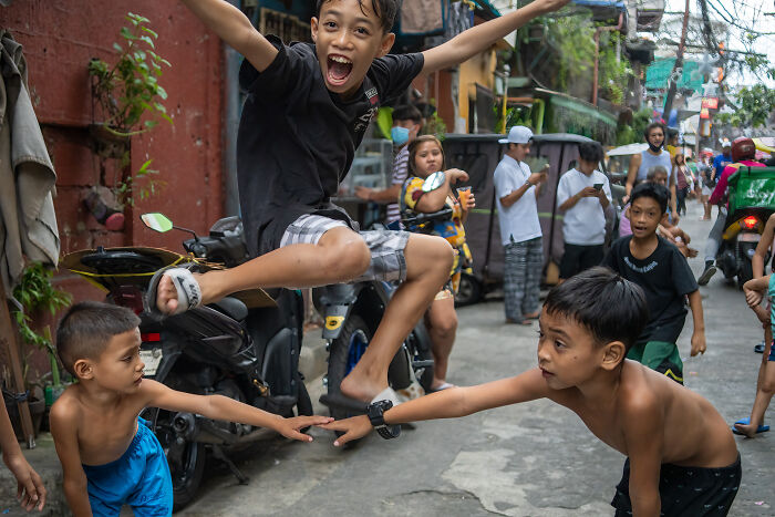 Children playing energetically in a lively street scene, capturing the beauty of cultures during international travel photography.