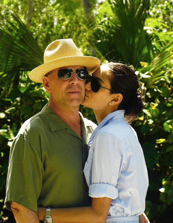 Bruce Willis and wife outdoors surrounded by greenery, sharing a tender moment amid heartbreaking health update. Bruce Willis and wife outdoors surrounded by greenery, sharing a tender moment amid heartbreaking health update.
