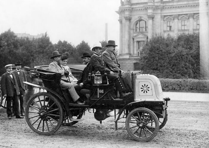 Early 1900s photo of people riding in one of the first cars showcasing how wild the first cars really were.