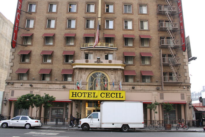 Hotel Cecil facade in an urban setting, known for its connection to some of the world's most baffling unsolved mysteries.
