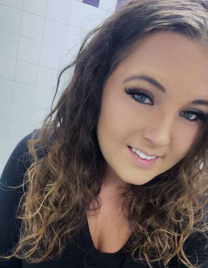 Young woman with curly hair smiling in a tiled room, related to viral impossible to visit truck stop location discussion. Young woman with curly hair smiling in a tiled room, related to viral impossible to visit truck stop location discussion.