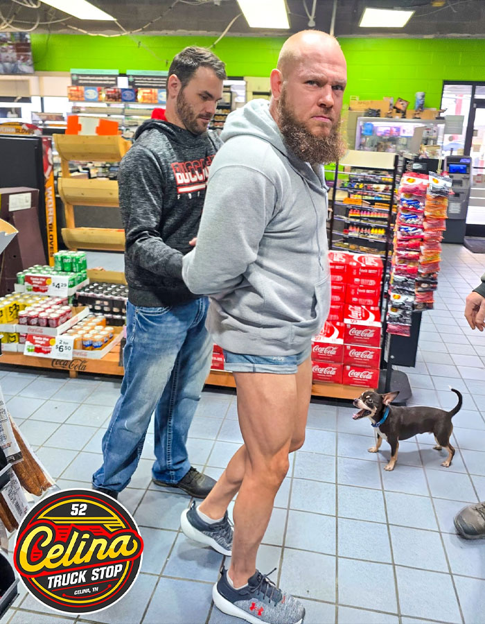 Man in shorts handcuffed in truck stop store with another man and small dog, related to viral impossible to visit truck stop location. Man in shorts handcuffed in truck stop store with another man and small dog, related to viral impossible to visit truck stop location.