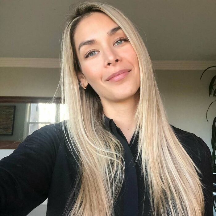 Blonde woman smiling indoors, showcasing beauty and elegance in a portrait reflecting Miss Universe winners style.