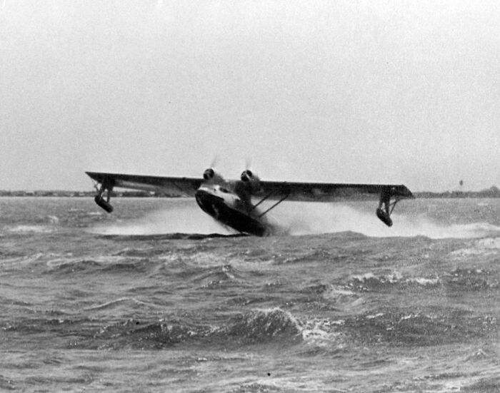 Seaplane landing on rough ocean waves captured in a rare historical photo showcasing wild moments from the past.
