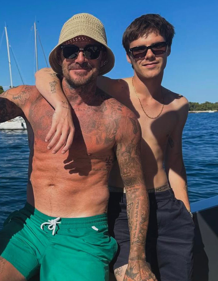 Cruz Beckham with a bulge posing shirtless on a boat alongside his tattooed dad David Beckham wearing a bucket hat and sunglasses. Cruz Beckham with a bulge posing shirtless on a boat alongside his tattooed dad David Beckham wearing a bucket hat and sunglasses.