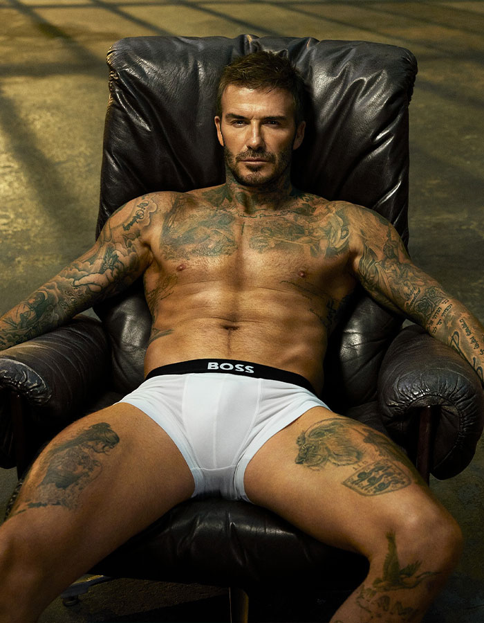 Shirtless man with tattoos reclining in chair wearing white BOSS underwear, highlighting Cruz Beckham's bulge viral moment. Shirtless man with tattoos reclining in chair wearing white BOSS underwear, highlighting Cruz Beckham's bulge viral moment.
