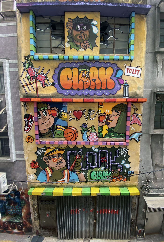 Colorful street art mural on building facade featuring cartoon characters, graffiti lettering, and vibrant urban canvas art.