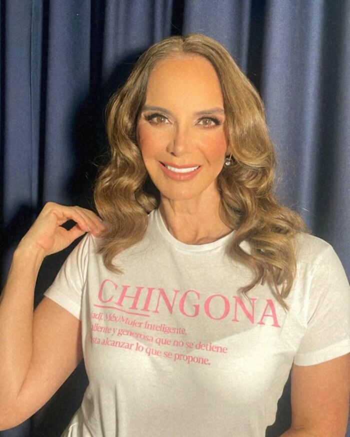 Woman with wavy hair smiling, wearing a white shirt, one of the 35 Miss Universe winners captured in stunning photos.