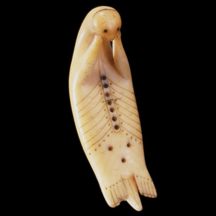 Carved historical ivory figure with intricate markings, showcasing an interesting story from past centuries.