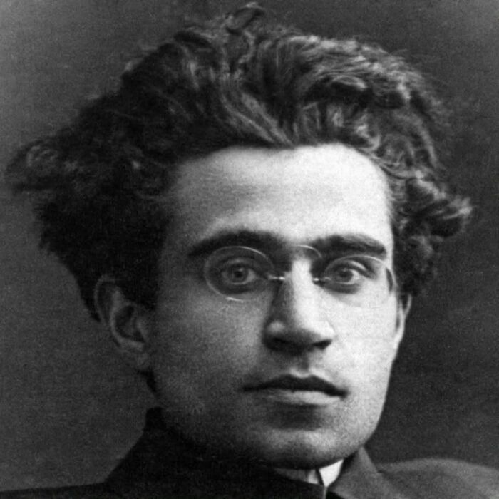 Black and white portrait of a young man with glasses and tousled hair, symbolizing common folk making a huge mark in history.