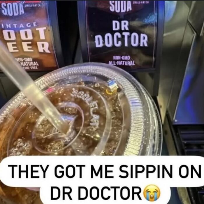 Close-up of a soda cup with a straw in front of unusual soda labels, featuring a caption about cursed images on an IG page.