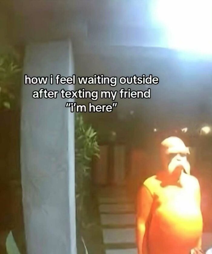 Person in orange costume standing outside at night with a broken sense of humor meme about waiting after texting friend.