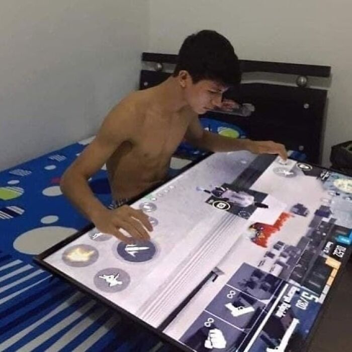 Teen playing on an oversized touchscreen device lying flat, reflecting a surreal and cursed image vibe for Instagram fans.