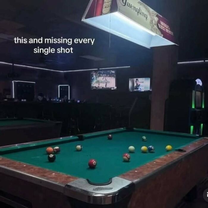 Pool table with scattered balls in a dim bar, caption about missing every shot, perfect for broken sense of humor memes.