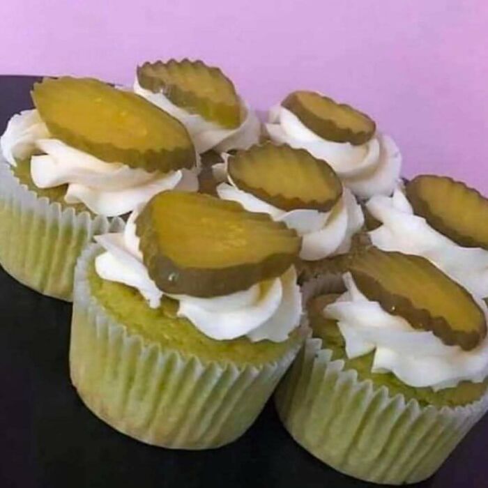 Cupcakes topped with white frosting and sliced pickles, an example of cursed images from a popular IG page disturbing 200K fans.
