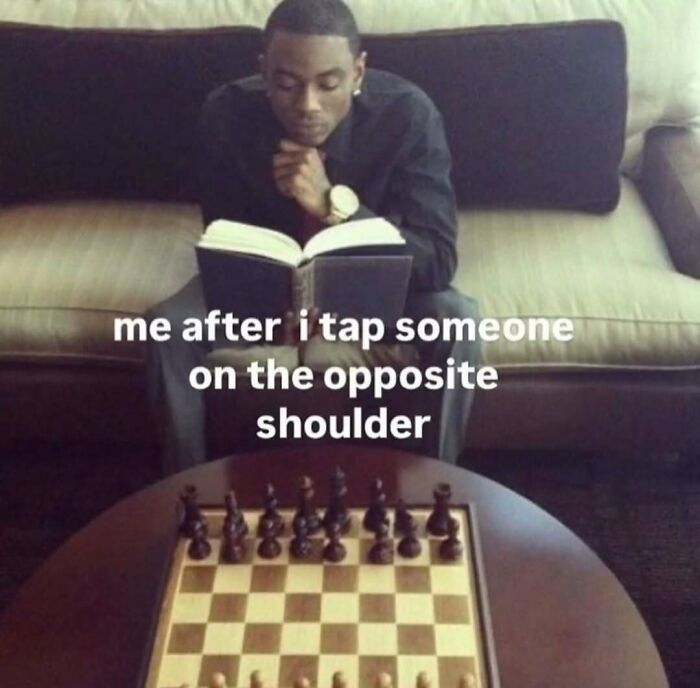Man sitting on a couch reading a book, with a chessboard in front, representing broken sense of humor meme.