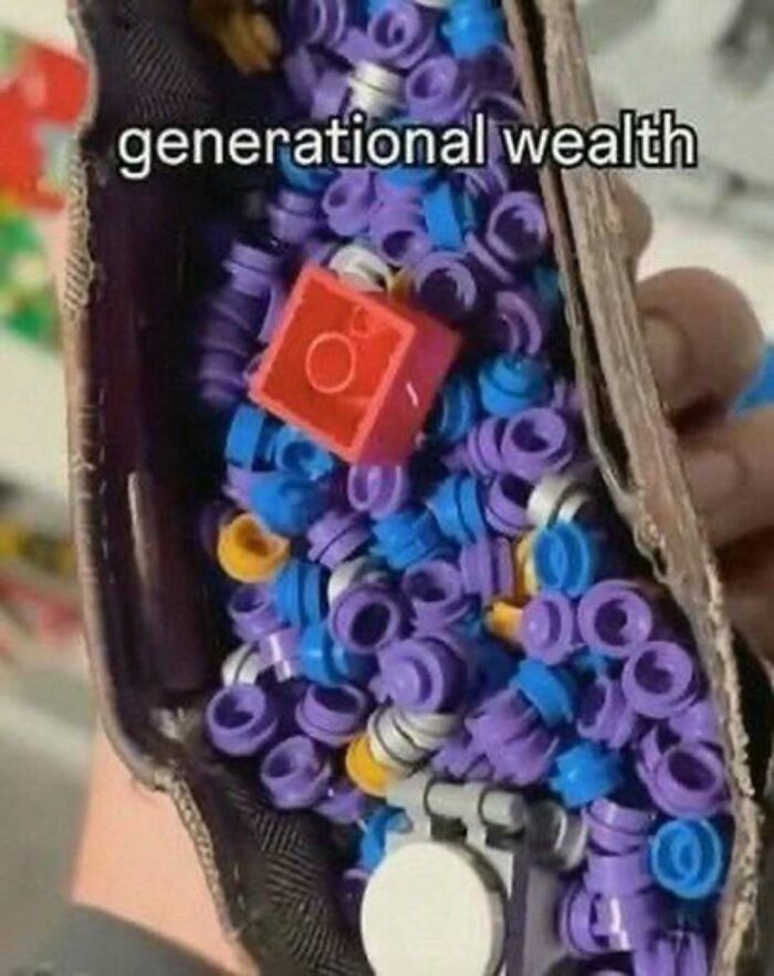 Close-up of small colorful toy rings with one red block labeled generational wealth, showing broken sense of humor meme.
