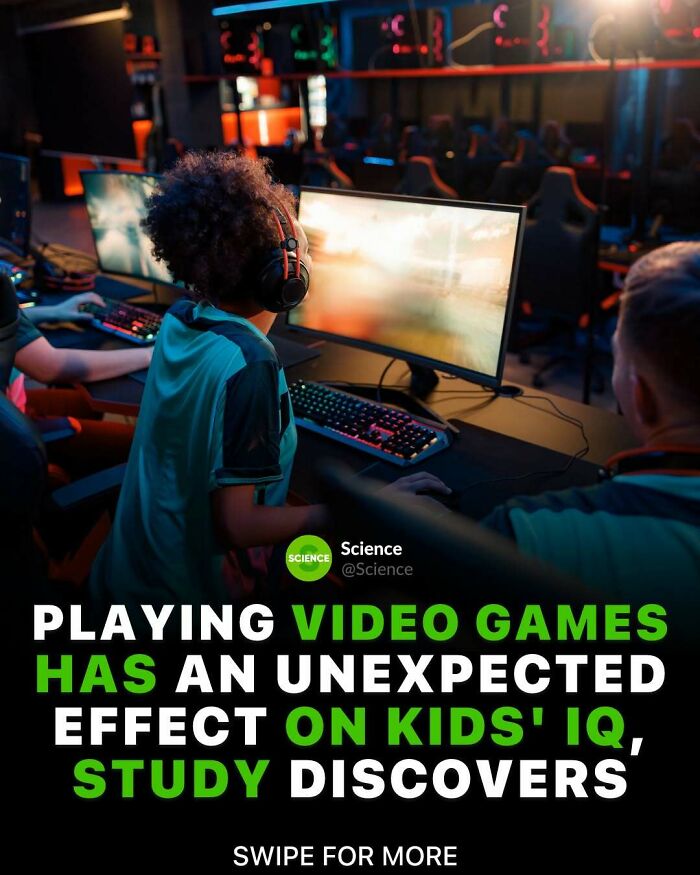 Child wearing headphones playing video games on computer in a dark room, related to world and science facts.