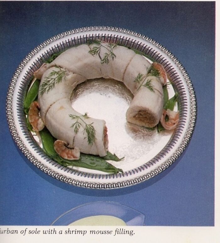Curban of sole with shrimp mousse filling on a vintage silver tray, evoking June Cleavers vintage closet era food presentation.