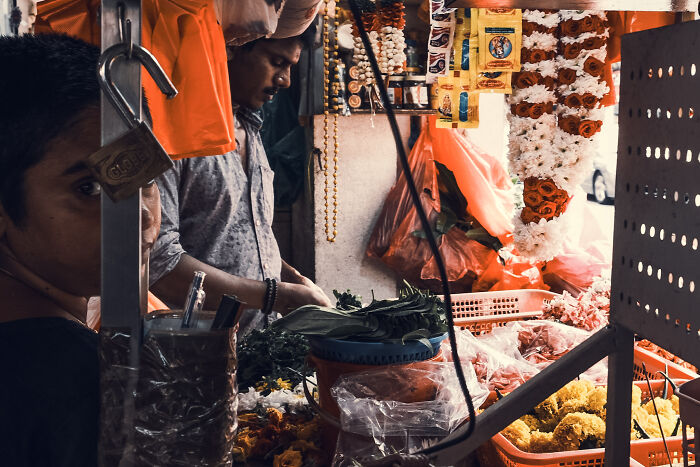 A photographer capturing poetic, cinematic images of a busy flower market with vibrant colors and everyday moments.