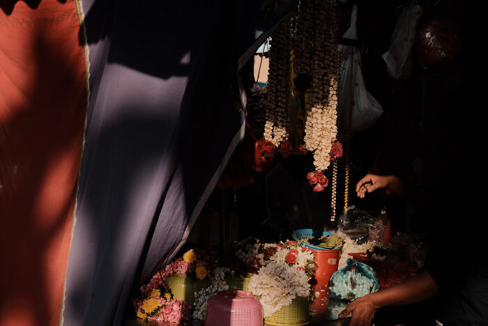 Photographer capturing poetic, cinematic moments of a flower market scene with dramatic light and shadow contrasts.