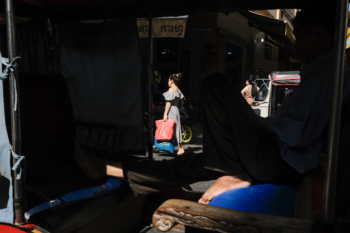 Cinematic image capturing an everyday street moment with contrasting light and shadow by a talented photographer.