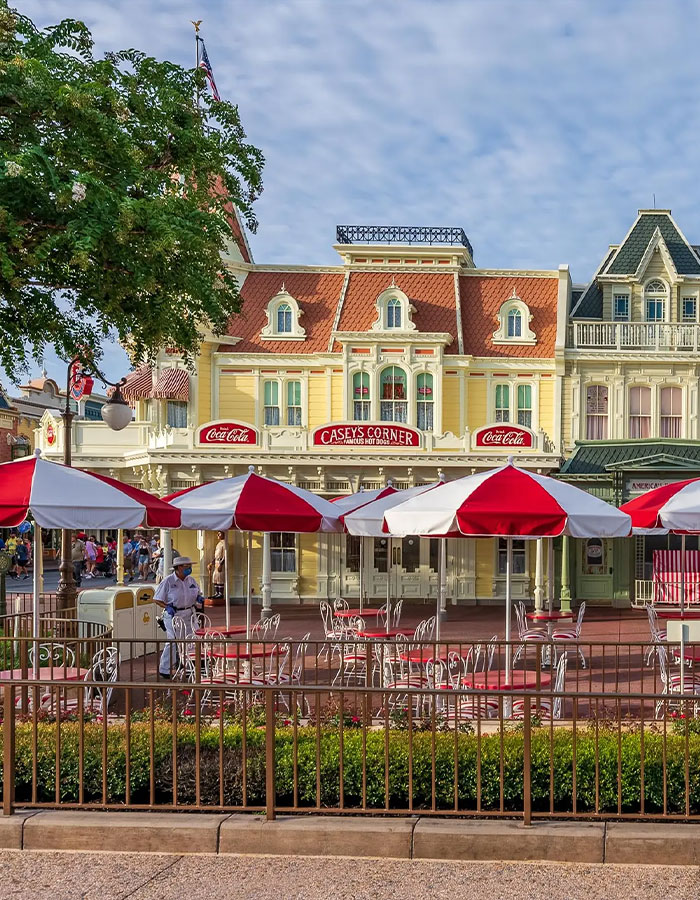 Outdoor seating with red and white umbrellas at Casey's Corner in Disney World, linked to violent Disney World incident keywords.