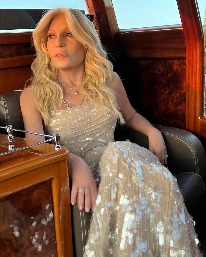Donatella Versace wearing a sparkling sequined gown sitting in a luxury car showcasing her stunning transformation.