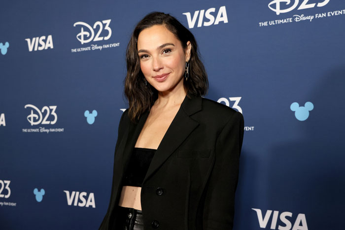 Gal Gadot posing at a Disney fan event, wearing a black blazer and crop top, career faces challenges. Gal Gadot posing at a Disney fan event, wearing a black blazer and crop top, career faces challenges.