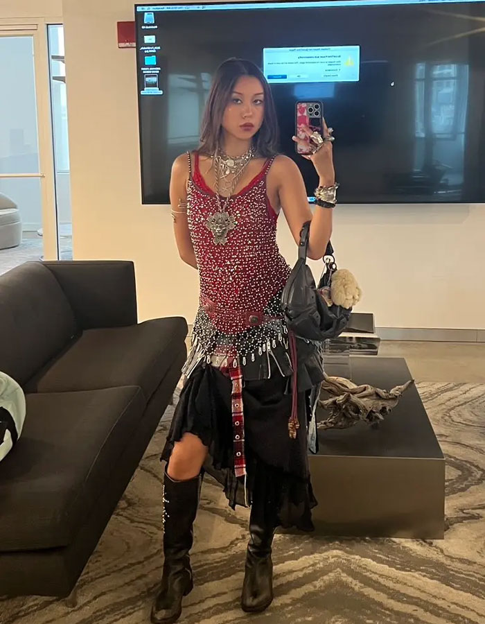 Gen Z worker taking a mirror selfie wearing an eclectic outfit challenging office dress code in a modern workspace.