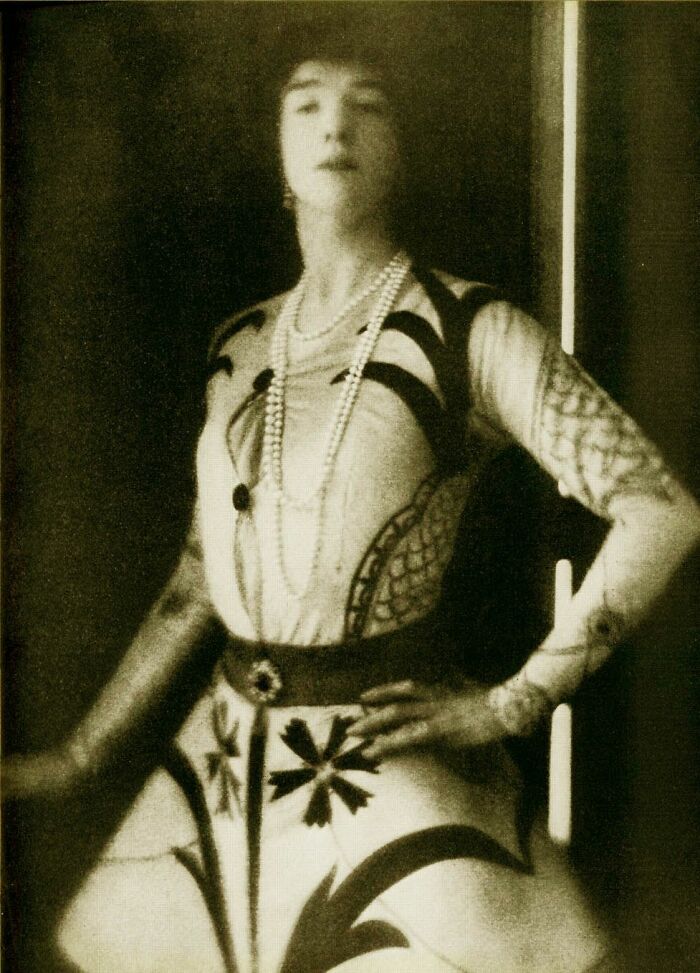 Black and white portrait of a woman in 20th century attire showcasing the triumph and tragedy era in history.
