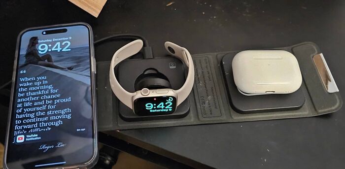 Smartwatch, wireless earbuds, and smartphone organized on a sleek charging station for efficient travel packing.