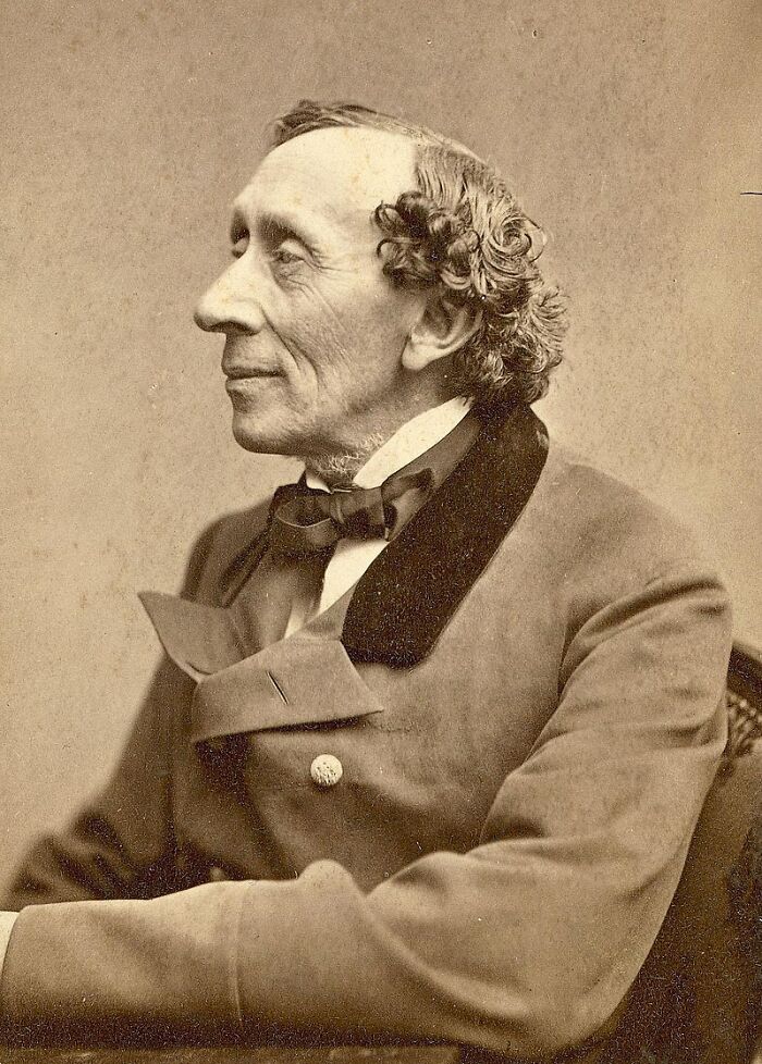 Sepia tone portrait of an older man with curly hair wearing a vintage suit, representing new facts and learning interest.
