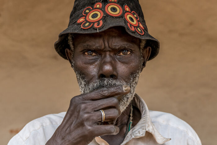 Portrait of an elderly man wearing a decorated hat, capturing the beauty of cultures through travel photography.