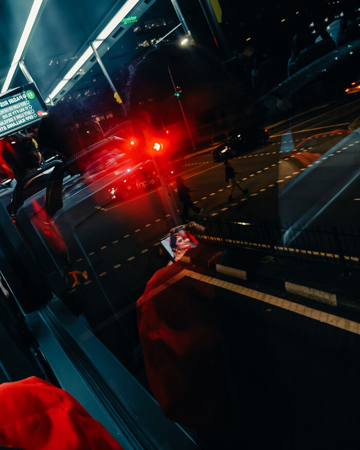 Cinematic photograph capturing reflections and red lights, turning an ordinary night scene into a poetic visual moment.