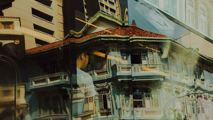 Reflection of colorful old buildings on a glass surface, showcasing poetic and cinematic photography of ordinary moments.