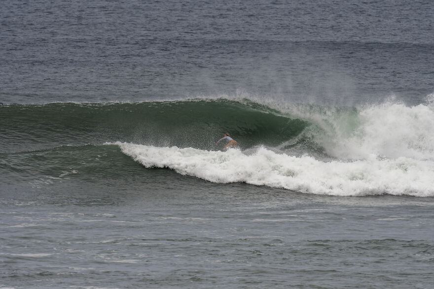 Surfer riding a large wave in the ocean, symbolizing how a one-way flight to Australia changed life and debt.