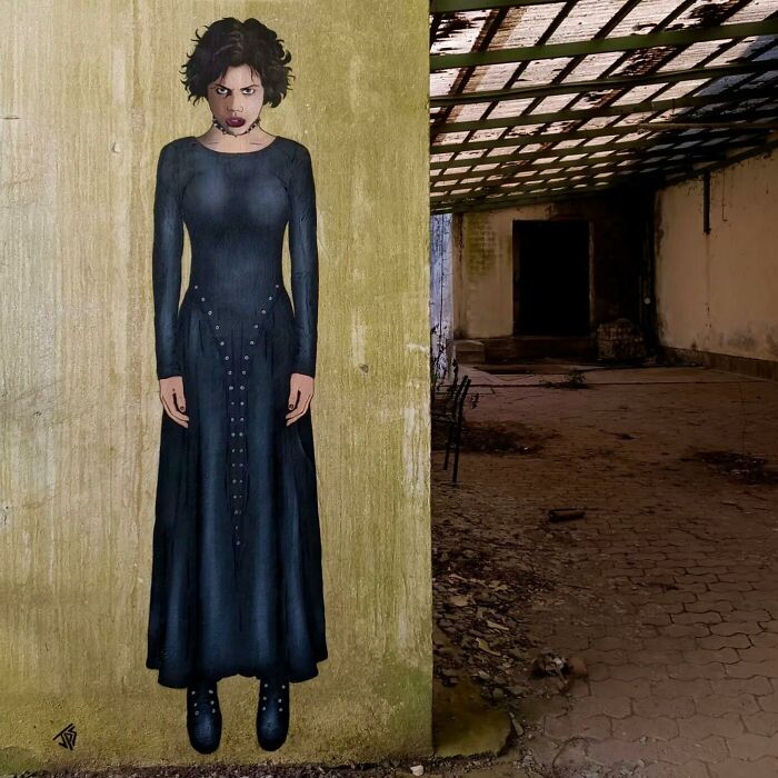 Graffiti artist creates interactive street art of a woman in a black dress blending into an abandoned building background.