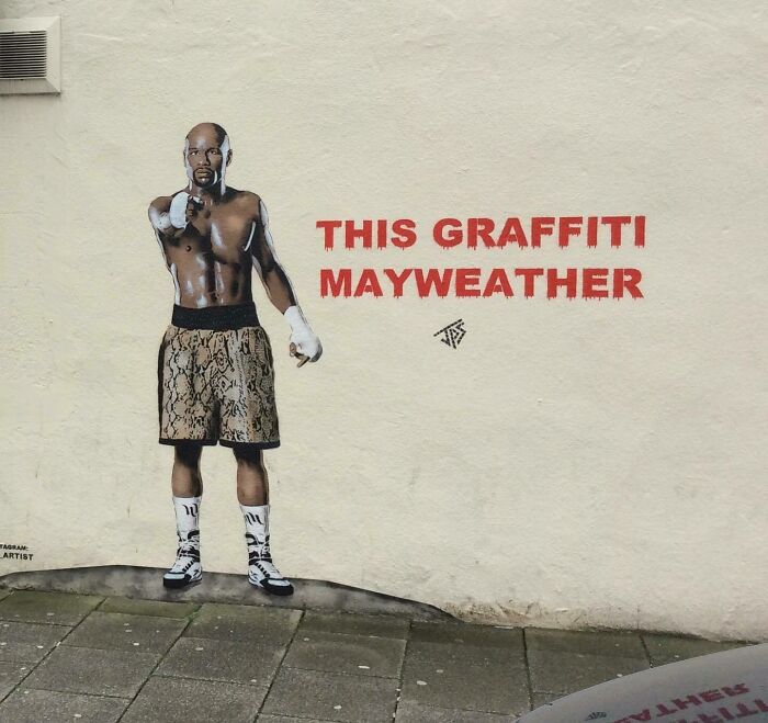 Graffiti art of boxer Mayweather on wall creatively interacting with the street surroundings to enliven urban space.