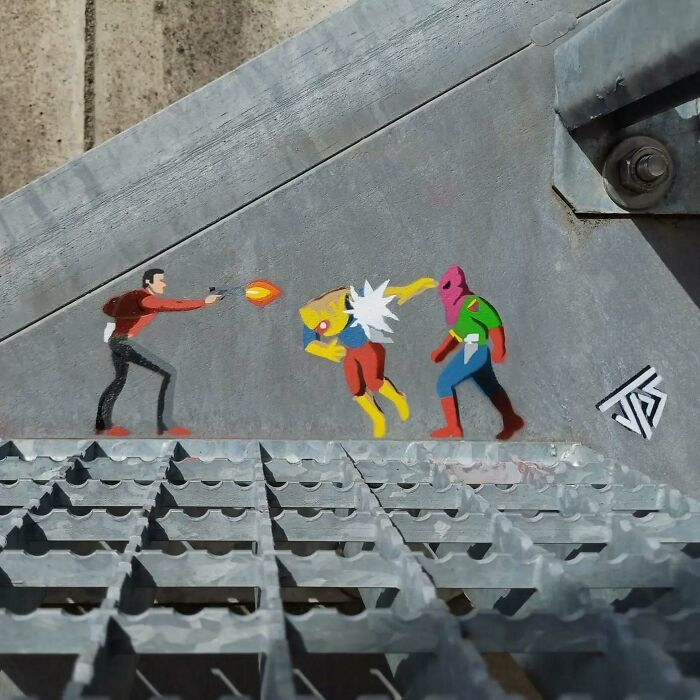 Street graffiti art interacting with surroundings, depicting characters in an action scene on an urban wall surface.