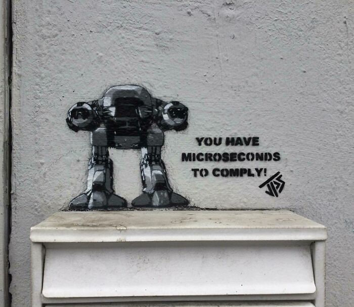 Graffiti art of a robotic figure interacting with a ledge on a wall, enhancing street environment creatively.