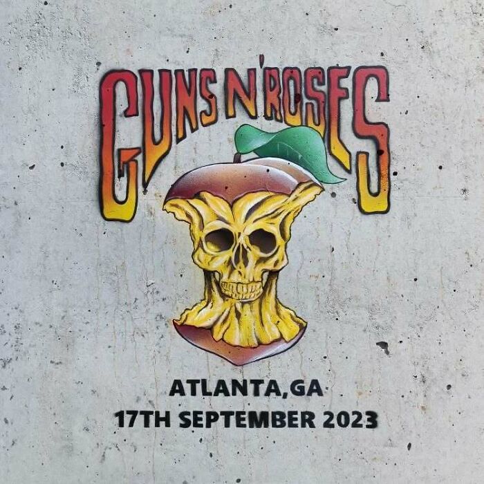Graffiti art of a skull apple core with Guns N' Roses text painted on a concrete wall, showcasing interactive street art.