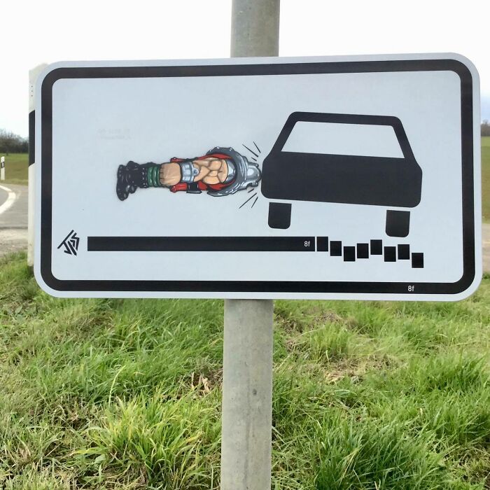 Street art graffiti interacts with a sign, showing a muscular character breaking through the side of a car icon.