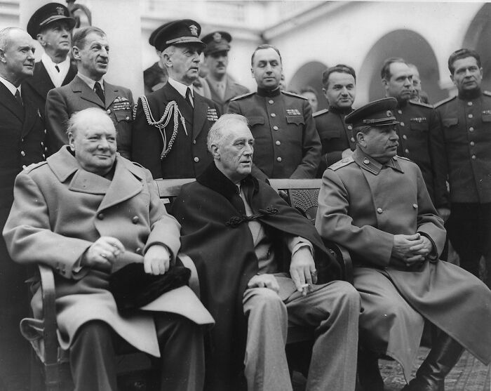 Wartime leaders seated together during a key 20th century moment representing triumph and tragedy in history.