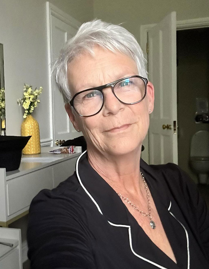 Jamie Lee Curtis wearing glasses and black top, responding to fan memes about her viral cleavage moment.