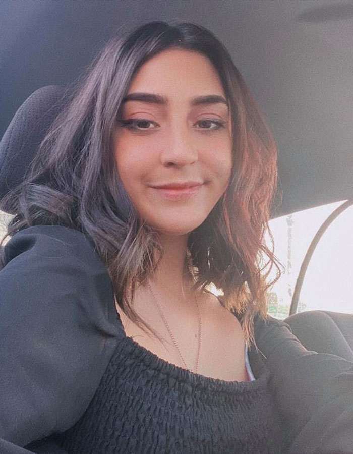 Young woman with dark hair smiling softly, sitting in a car, related to 7-Eleven manager coworker incident.
